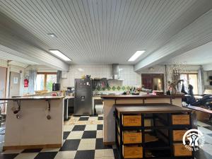 a large kitchen with a counter and a refrigerator at Gîte de séjour La Dressère in Formiguères