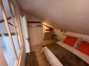 a bedroom with a bed and a large window at Gîtes du Fort in Collonges