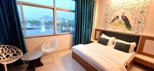a bedroom with a bed and a window at Antariksh -A beautiful homestay near Lake Pichhola in Udaipur