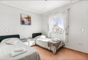 a bedroom with two beds and a window at Casa Lanjaron in San Miguel de Salinas +32 photos