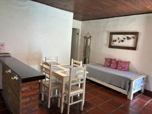 a room with a bed and a table and chairs at Chalés Bambá in Ilhabela