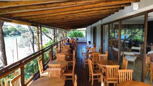 a restaurant with wooden tables and chairs on a balcony at Píer 135 Escarpas in Capitólio