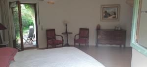 a bedroom with a bed and two chairs and a dresser at Geschmackvolles Zimmer in Steinhude in Wunstorf
