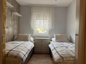 two beds in a small room with a window at Chatka w Narwi in Narew