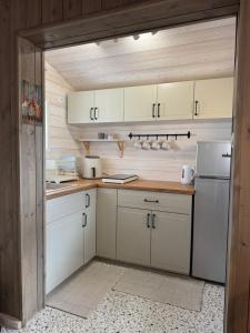 a kitchen with white cabinets and a refrigerator at Chatka w Narwi in Narew