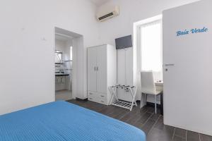 a white bedroom with a blue bed and a table at Le Camere Di Anna in Gallipoli +40 photos