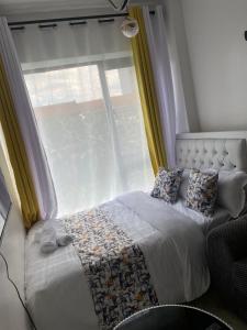 a bed in a room with a window and a bed sidx sidx sidx at CozMila homes in Kiambu