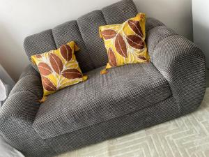 a gray couch with two pillows on it at CozMila homes in Kiambu
