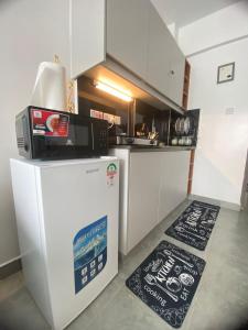 a kitchen with a microwave on top of a refrigerator at CozMila homes in Kiambu
