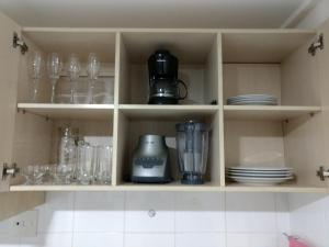 un armario de cocina con gafas y electrodomésticos en Manaíra Palace 419, en João Pessoa