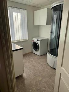 a bathroom with a shower and a washing machine at Paide Apartment in Paide