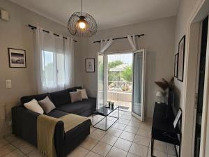 ein Wohnzimmer mit Sofa und Fenster in der Unterkunft Casa Sofia in Dassia