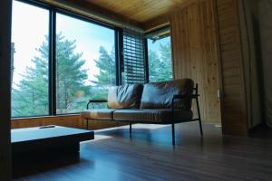 a living room with a couch and a large window at Byeoldeul-ui Gichim Pension in Inje