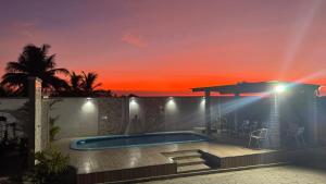 a villa with a swimming pool at sunset at Pousada Oásis das Dunas in Santo Amaro