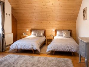two beds in a room with wooden walls at Ferienhaus Jenig in Jenig