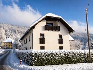 a building with snow on the ground next to a street at Ferienhaus Jenig in Jenig