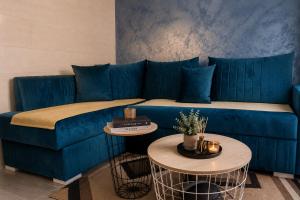 a blue couch in a living room with two tables at Blue Skies in Podgorica