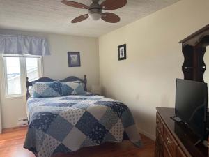 a bedroom with a bed and a ceiling fan at Long Beach Lookout Vacation Rental in Twillingate