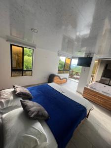 a bedroom with a large bed with blue sheets and pillows at Eco hotel el molino in San Luis