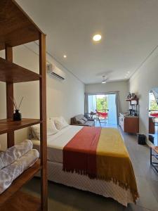 a bedroom with a bunk bed and a living room at Residencial Mirante in Itacaré