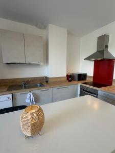 a kitchen with a white counter top and a sink at Le Panier in Alixan