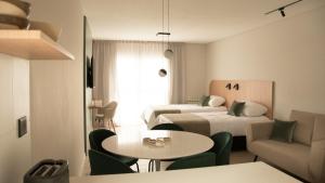 a hotel room with two beds and a table and chairs at VAYU LuxuryLofts in Bahía Blanca +34 photos