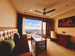 a room with a bed and a table and a window at Mokshada Hotel & Resort A Premium Property Near Jaypee in Mussoorie