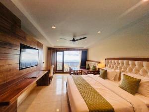 a hotel room with a bed and a flat screen tv at Mokshada Hotel & Resort A Premium Property Near Jaypee in Mussoorie
