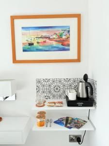 a painting on a wall above a white shelf at Tŷ Treflan in Aberdyfi