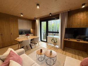 a living room with a couch and a table and a kitchen at Apartmán Forest, Tatranská Štrba in Tatranska Strba