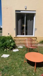two chairs and a table in front of a window at Le Jolibardet in Vieillevigne