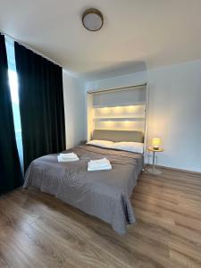 a bedroom with a bed with two towels on it at VIRIDIS Apartment in Františkovy Lázně
