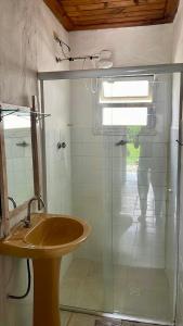 a bathroom with a sink and a glass shower at Chalés Bambá in Ilhabela +39 photos