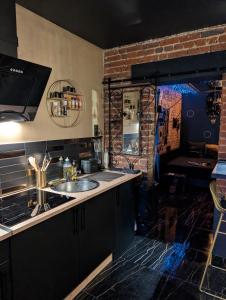 a kitchen with a sink and a brick wall at Blacroom de l'Artois in Souchez +25 photos