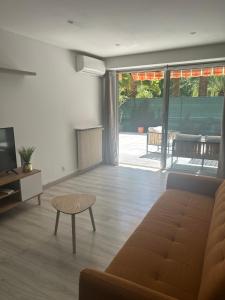 a living room with a couch and a table at L'échappée Méditerrannée in Vallauris
