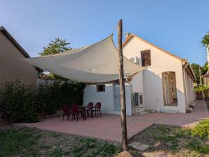 a white tent on a patio in front of a house at Maison Bátori Tarczal in Tarcal