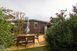 a patio with a table and chairs and a house at Flinders Ranges Bed and Breakfast in Hawker