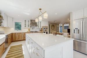 a kitchen with white cabinets and a large island at Tideview Estate in Cumberland Foreside