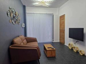 a living room with a couch and a tv at S & R Homes in Tacloban