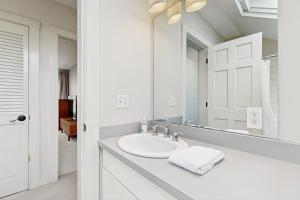 a white bathroom with a sink and a mirror at Tideview Estate in Cumberland Foreside +54 photos