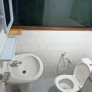 a white bathroom with a sink and a toilet at Pavani Villa Kandy in Peradeniya +53 photos