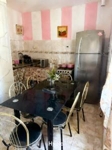 a kitchen with a black table and a refrigerator at challet1 in Yerba Buena