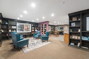 a living room with blue chairs and bookshelves at Library INN - Boutique Rooms - Free Breakfast - Hot Tub in Lava Hot Springs