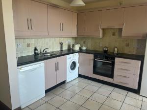 a kitchen with a sink and a dishwasher at Central Two Bed Apartment looking over the Harbour in Dunfanaghy