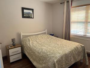 a bedroom with a bed and a dresser and a window at Central Two Bed Apartment looking over the Harbour in Dunfanaghy
