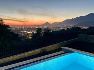 a swimming pool with a view of the city at sunset at Villa in Čeluga