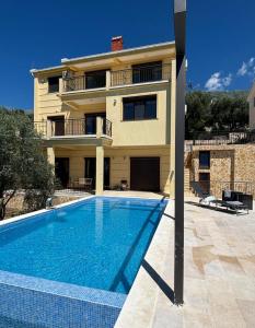 a villa with a swimming pool in front of a house at Villa in Čeluga