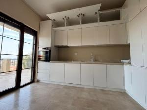 a kitchen with white cabinets and a large window at Villa in Čeluga