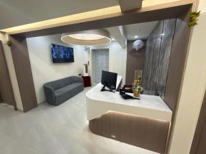 a lobby with a desk with a laptop and a couch at Hotel Yagnik Inn in Rajkot +35 photos