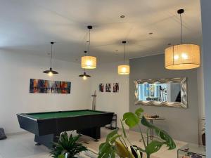 a living room with a pool table and pendant lights at 8villa in St. Julianʼs
